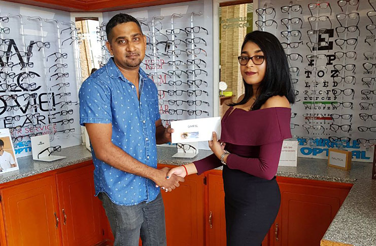 Romeo Singh (left) of Miracle optical hands over his company's sponsorship.