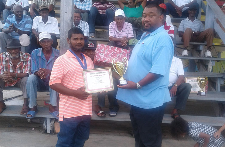 Tyrone Pottaya receives his Dr Tulsi Dyal Singh award from BCB president Hilbert Foster.