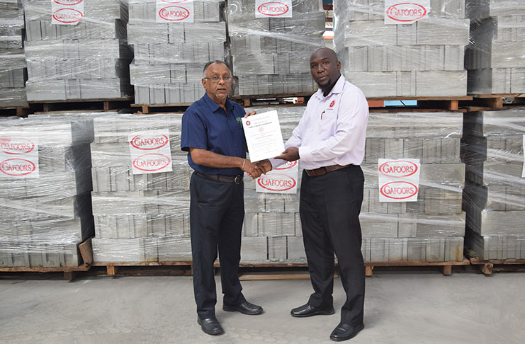 Gafsons Industries Limited Factory Manager Bharrath Rampersad receives the certification from Al Donavon Fraser, Head of the GNBS Certification Services Department