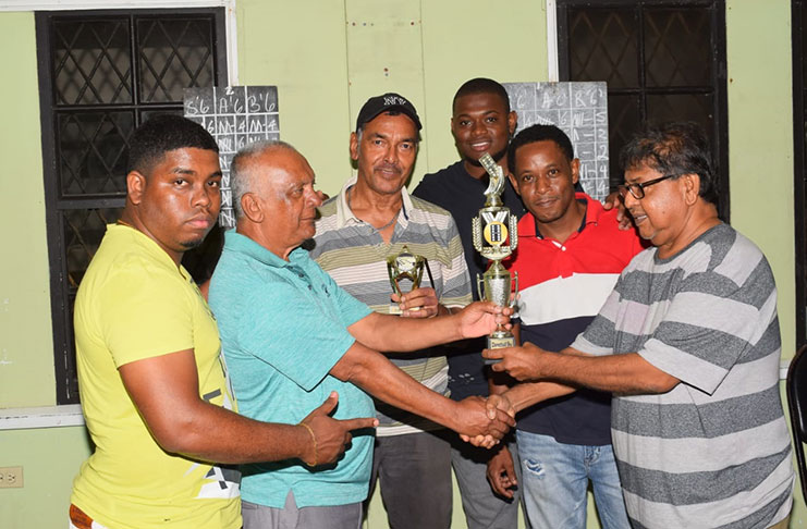 Organiser Manniram Shew (right) hands over the winning trophy to Muntaz ‘Bhajee’ Ali in the presence of other team members.