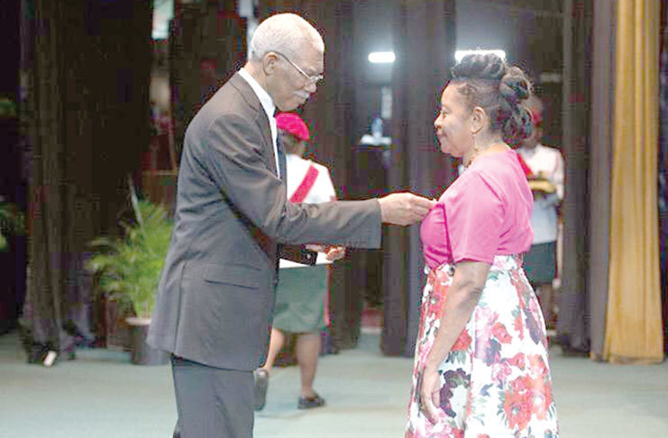 Dr. Ruth Benjamin- Huntley being conferred with the Golden Arrow of Achievement by President David Granger