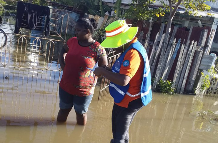 A CDC official interacts with a resident whose house was flooded (CDC photo)