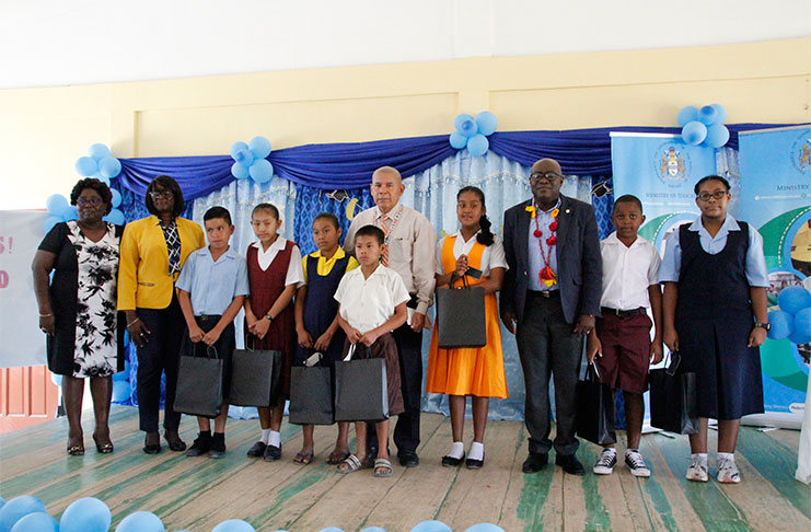 Social Cohesion Minister, Dr George Norton, and senior education officials with the region’s top 10 pupils
