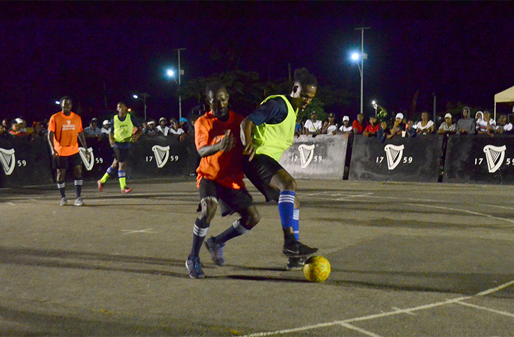 Sparta Boss’ Gregory ‘Jackie Chan’ Richardson shields the ball from an Alexander Village player during their opening group stage match at the National Cultural Centrr tarmac.