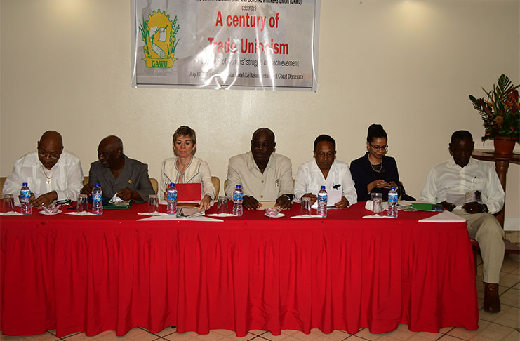 Minister within the Ministry of Labour, Keith Scott (second left) along with labour leaders and officials at the head table (Adrian Narine photo)