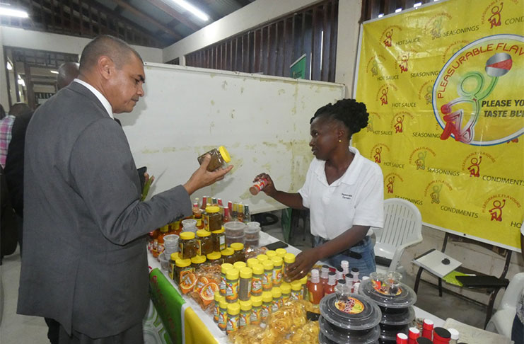 Minister of Business Haimraj Rajkumar having a look at the products of Pleasurable Flavours-- a Linden-based business