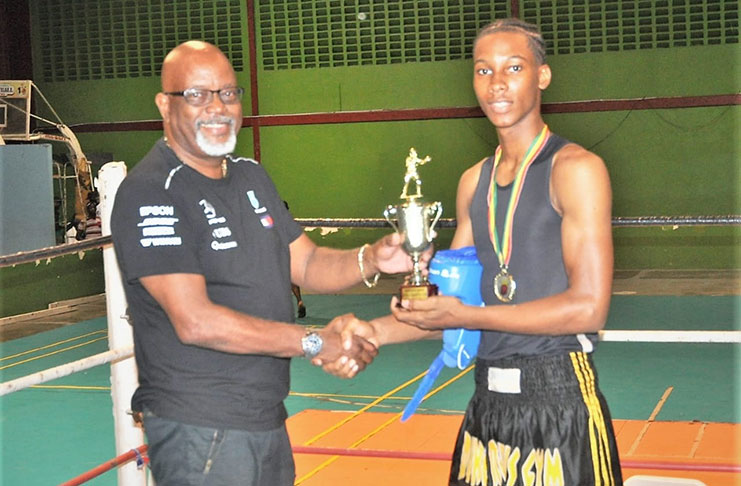 CEO of Secure Innovations and Concepts Harold
`Top Gun’ Hopkinson (left) hands over the
Best Boxer Trophy to Shemar Halley
of Forgotten Youth Foundation.
Halley also received a headguard from GBA president
Steve Ninvalle and a monetary donation from CEO of
Brisco Promotions Seon Bristol