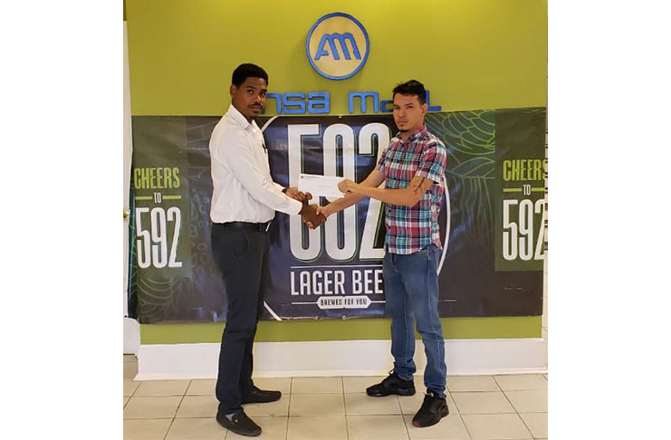 592 Beer Brand Manager Seweon McGarrell hands over the sponsorship package to tournament coordinator Michelangelo Jacobus at the Ansa McAl head office.