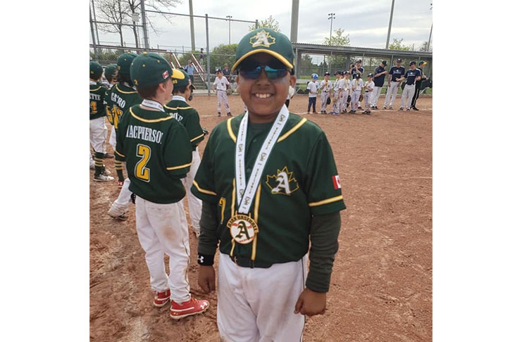 Ayden Ramcharran poses with one of his several awards.