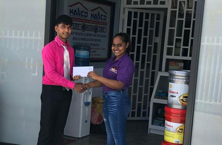 GMR&SC representative Teekaram Jainarine (left) receives the cheque from Motor Trends' Neshana Deodas.