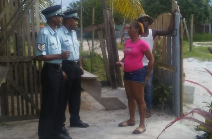 Timehri residents interacting with two police sergeants who were part of the visiting team