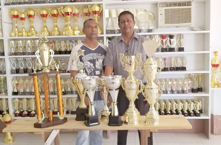 General Manager of Trophy Stall, Ramesh Sunich (right) presents trophies to General Manager of Nand Persaud Group Of Companies and Coordinator of the Sprint Classic meet, Mohendra  Persaud.