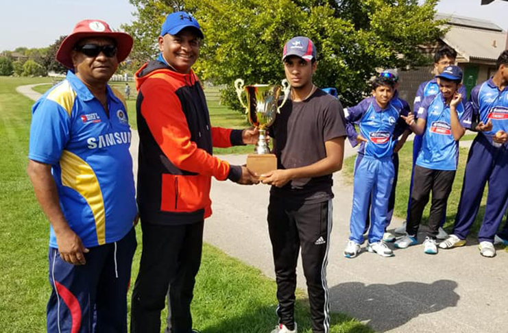 SCA Blues skipper Arjuna Sukhu (right) collects the winner’s trophy. Manager Vish Jadunauth is at left.