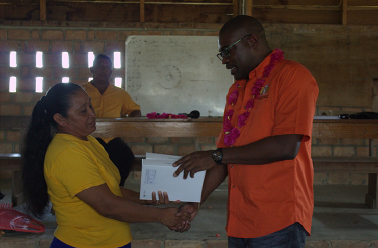 Minister of Public Infrastructure David Patterson hands over electronic tablets to Loretta Marco, the head mistress of Katoka Nursery School