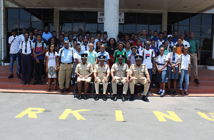 Senior GPF officers (seated) flanked by students who completed their work study programme