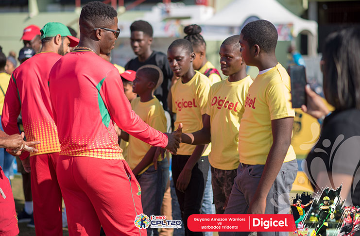 Sherfane Rutherford (in forefront), along with other members of the Guyana Amazon Warriors, meet members of the Buxton Cricket Academy, compliments of Digicel.