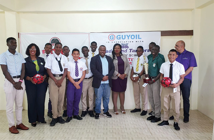 Members of GUYOIL/Tradewind Tankers and Petra Organisation pose with some students who will be participating in the Schools Football U-18 tournament.