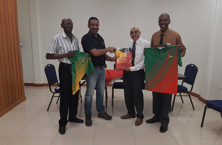 GOA president, K. A Juman Yassin (2nd right) hands over one of the track suits to Fullbore VC Dylan Fields in the presence of team members Ryan Sampson (right) and Ransford Goodluck.
