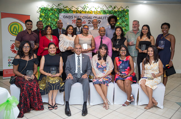 Minister of Business, Hon. Haimraj Rajkumar [seated third left], Director of Manufacturing and Marketing of the Ministry of Business, Dominic Gaskin [third right, back row] and Chairman of the National Standards Council, Rowen Willabus [second right, back row] along with the prize winners