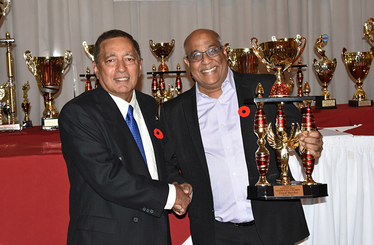 OMSCC president Azeem Khan hands over a trophy to vice-president, Feizal Bacchus, for his outstanding contribution to the league.