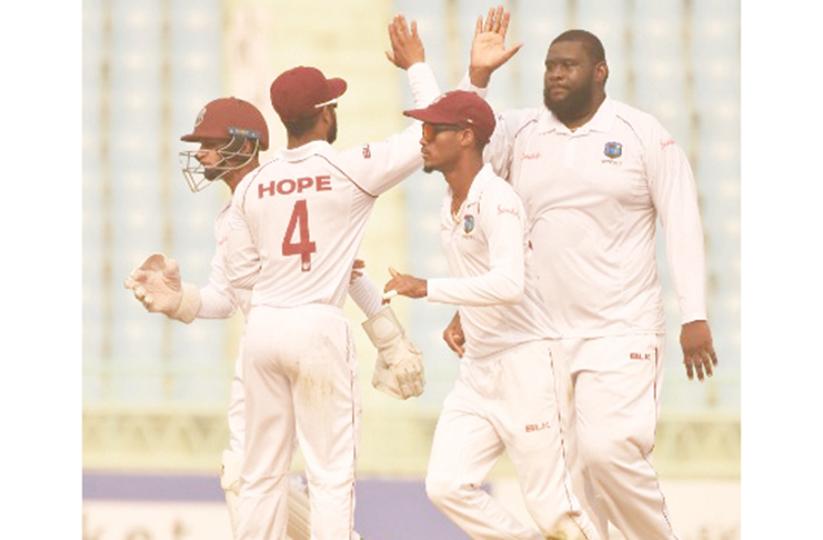 Off-spinner Rahkeem Cornwall (right) celebrates another wicket with teammates on the opening day of the one-off Test against Afghanistan yesterday. (Photo courtesy CWI Media)