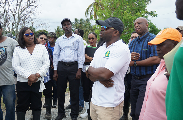 NAREI representative Eon Sampson (white t-shirt) briefs Minister of Foreign Affairs Dr Karen Cummings (left) and diplomats during a visit to the flood-affected communities in Region Five (Carl Croker photo)