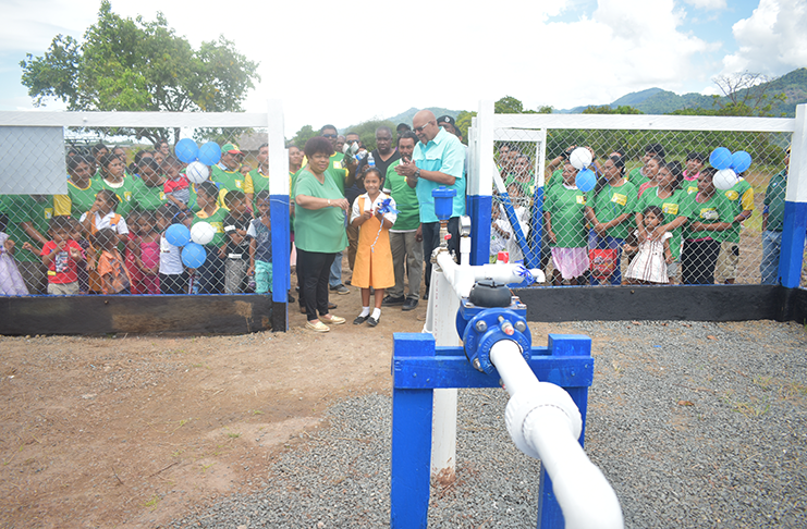 A student of the Moco Moco Primary school cuts the ribbon to commission the well station