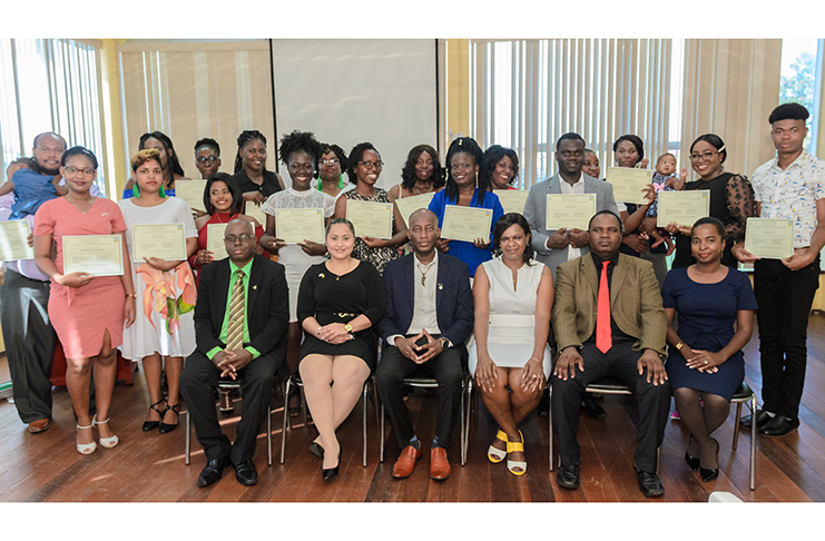 Officials of the programme (seated) flanked by graduants of the Financial Literacy and Small Business Training Programmes. (Delano Williams photo)