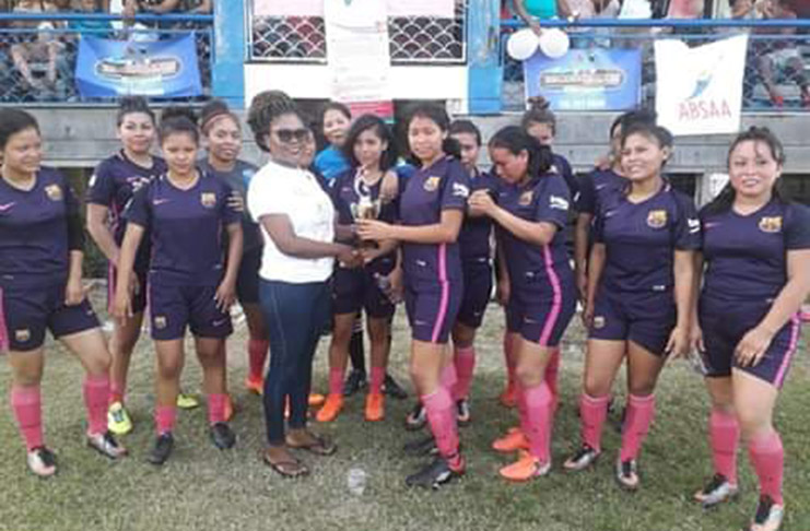 : Kanaimas Ladies captain, Ellisa Boscome, collects the first place trophy from Cancer Institute of Guyana representative, Monette Harry.