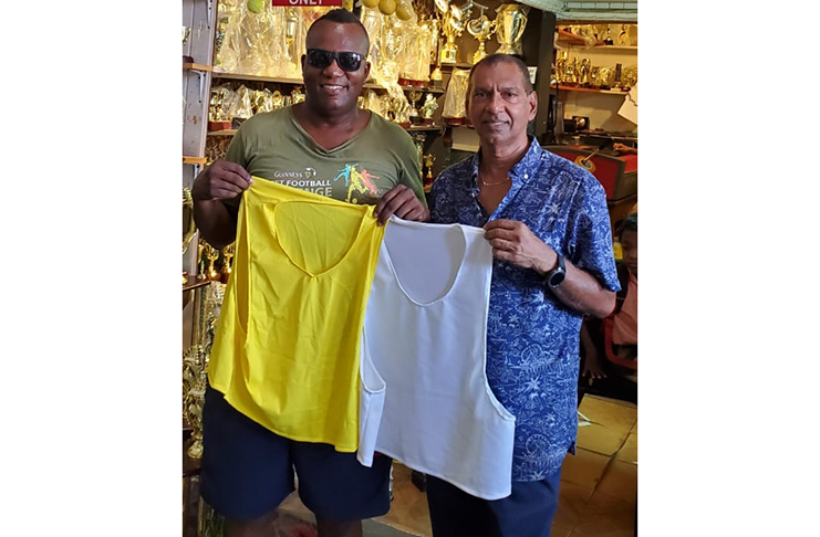 Trophy Stall owner Ramesh Sunich (right) and Wayne Griffith display the vests that will be used in the inaugural Rio Indoor Streetball championship at the National Gymnasium on Mandela Avenue.
