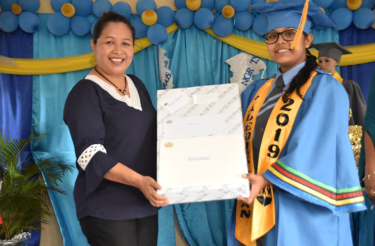 Minister of State, Dawn Hastings-Williams, presents valedictorian, Renesha Shiwbalak with a laptop computer, in recognition of her accomplishments
