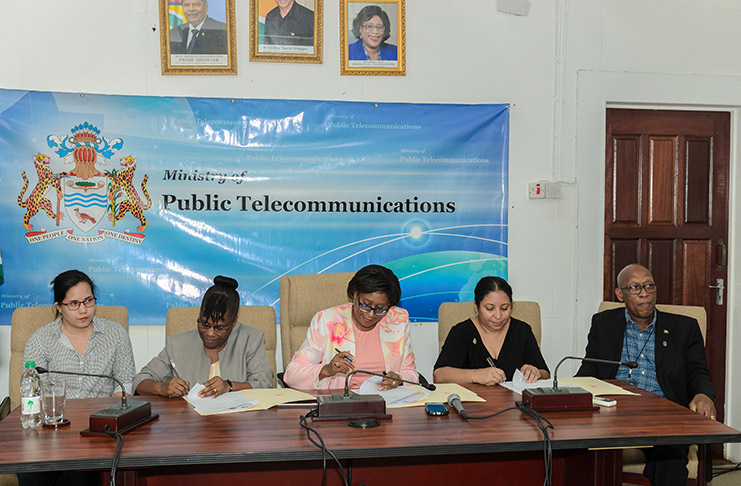 Minister Catherine Hughes and representatives from both her ministry and the University of Guyana, including Professor Michael Scott, right, appending their signatures to the agreement