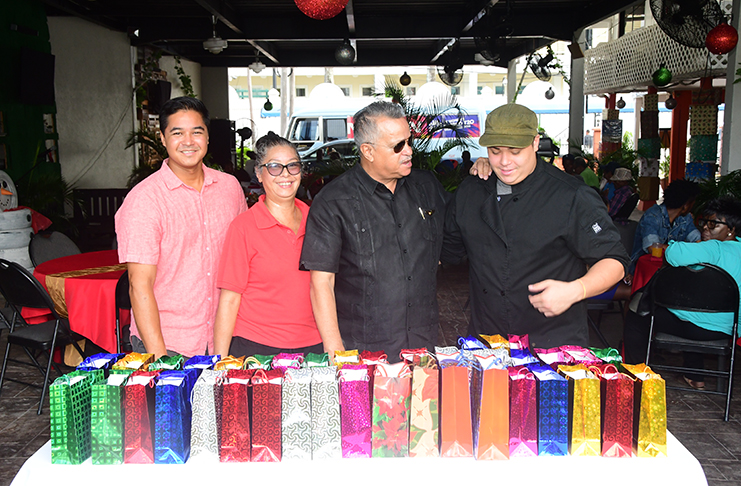 The Gouveia family which has for years been extending Christmas joy to the veterans
and others. From left, Captain Gerry Gouveia (Jnr); Captain Debbie Gouveia; Chief
Executive Officer (CEO), Captain Gerald (Gerry) Gouveia (Snr) and Kevin Gouveia,
the Chief Chef, pose behind the gifts that were distributed to the seniors.