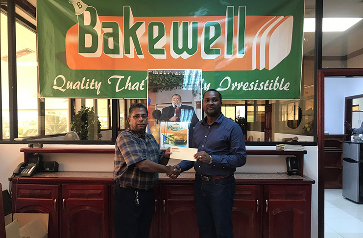 General Manager of Bakewell, Rajin Ganga presents the sponsorship cheque to GFF President, Wayne Forde.