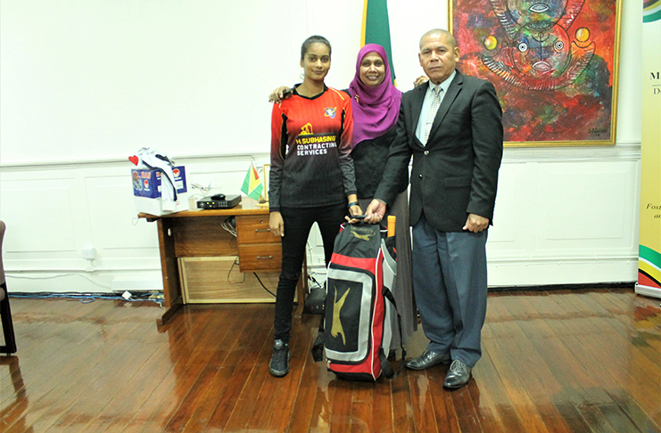 Minister Norton presents Sarah Amin with the cricket kit. The teen’s mother Shameza Amin is at centre.