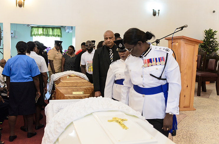 Deputy Commissioner of Police, Maxine Graham, senior police officers and former Commissioner of Police, Seelall Persaud, view the body of Eastman at the Central Seventh Days Adventist Church