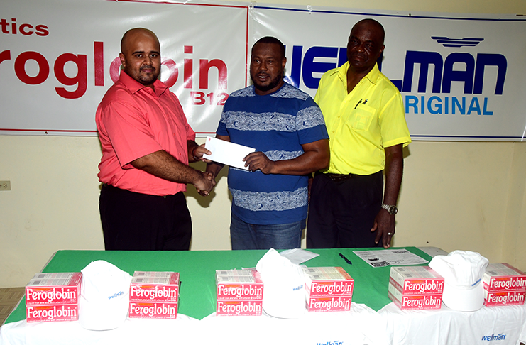 Marketing Manager for Vitabiotics, Michael Jessimy, hands over the sponsorship cheque to Petra co-director Troy Mendonca in the presence of Logistics officer Lawrence Griffith (Adrian Narine photo)