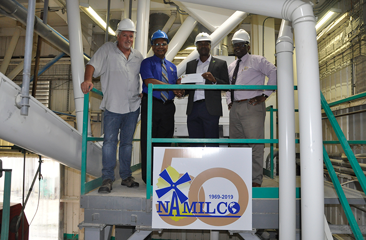 Managing Director of NAMILCO, Bert Sukhai (2nd left), hands over the cheque to GFF president Wayne Forde in the presence of NAMILCO’s Ralph Hemsing (left) and Fitzroy McLeod.