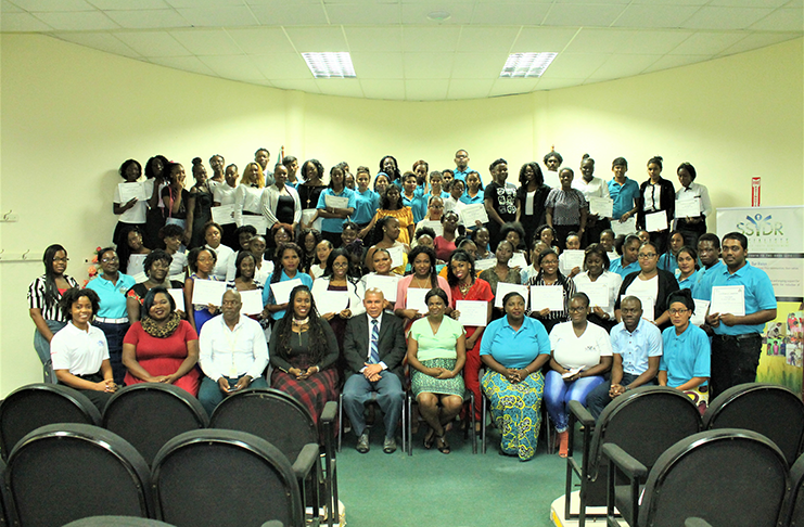 Social Cohesion Minister, Dr. George Norton and Assistant Director of Youth, Leslyn Boyce (seated centre) pose with trainers (seated) and participants of the job readiness skills training programme