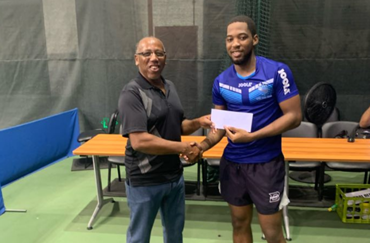 Shemar Britton collects his prize for his Tournament win from Mr Edwin Canes, General Secretary Trinidad and Tobago Table Tennis Association.