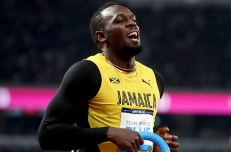 Usain Bolt grimaces after completing a lap at the new National Stadium in Tokyo.