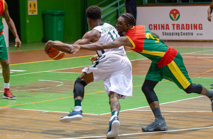 Guyana’s Ray Victor beats his Grenadian defender on his way to scoring during his side’s 97 – 75 points win at the Cliff Anderson Sports Hall. (Delano Williams Photos)