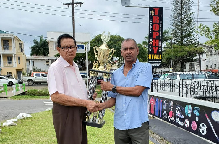 KMTC president Justice Cecil Kennard accepts the Champion Jockey trophy from Trophy Stall CEO Ramesh Sunich.