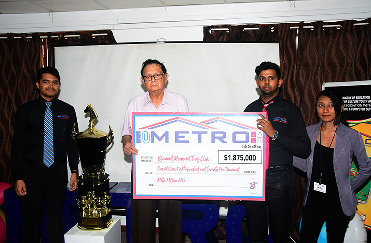 From left, Management Trainee Andrew Hing, KMTC president Justice Cecil Kennard accepting the million-dollar cheque from Management Trainee Prakash Bahadur in the presence of Sanshya Bhagwandin. (Adrian Narine photo)