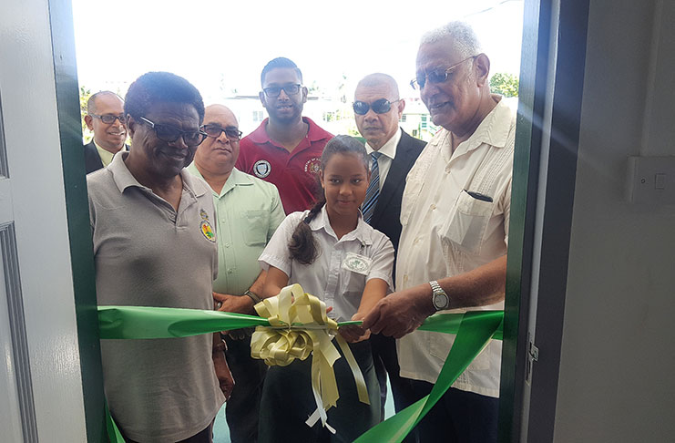 A student from Anna Regina Multilateral Secondary School (ARMS) cut the ceremonial ribbon to officially open the NDIA office at Cotton Field