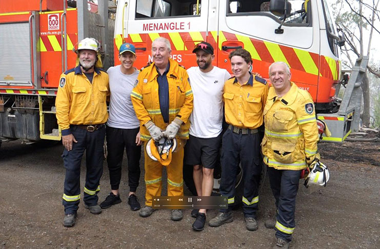 Australia cricketers Tim Paine and Nathan Lyon pose with firefighters as they visit areas affected by bushfires in Southern Highlands, New South Wales, Australia, January 8, 2020 in this still image obtained from social media video. (CRICKET AUSTRALIA/via REUTERS)