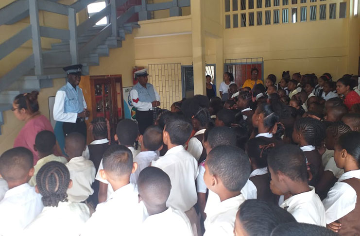 Policemen explaining aspects of road safety to pupils of May’s Primary School, Essequibo Coast