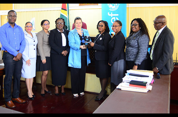 UNICEF Representative, Sylvie Fouet (fifth left) hands over a web camera to Chancellor of the Judiciary, Justice Yonette Cummings-Edwards. Also in the photo are Chief Justice, Roxane George-Wiltshire; representatives of the Regional Education Officer (REO) and Regional Health Officer (RHO) of Region 4 (Samuel Maughn photo)