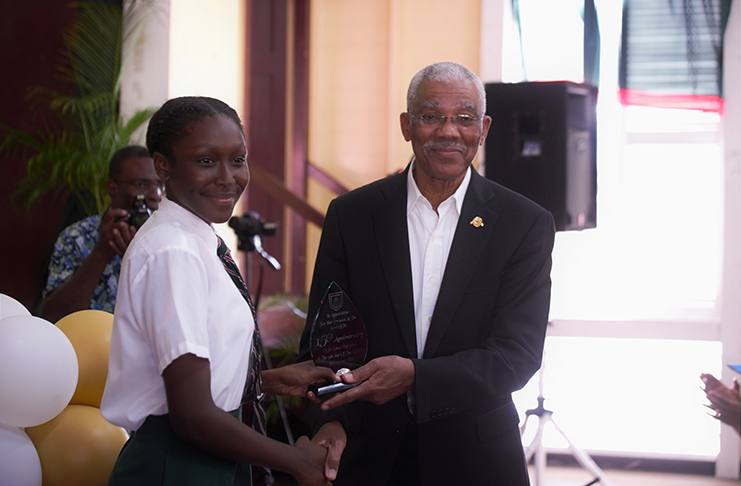 A student of the Bishops’ High School presenting President David Granger with a token of appreciation
