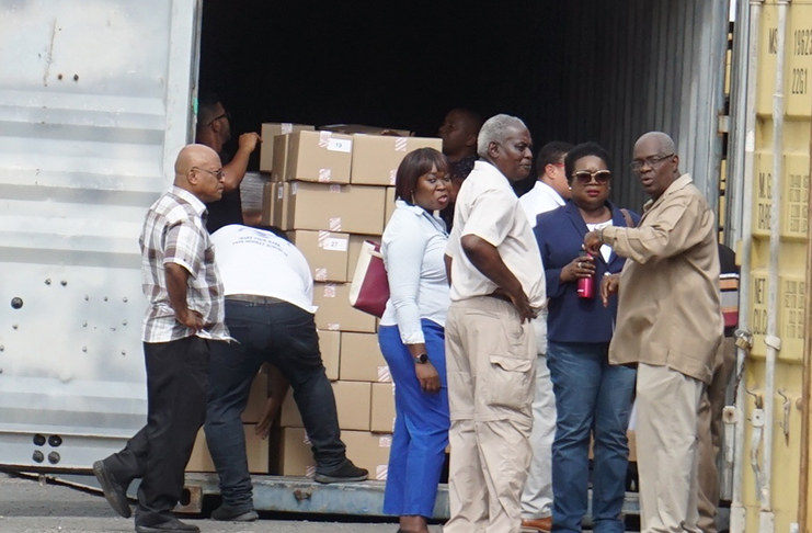 Chief Elections Officer, Keith Lowenfield; GECOM Commissioner,
Robeson Benn, and other officials observe as
the ballot papers are offloaded at GECOM’s head office
(Carl Croker photo)